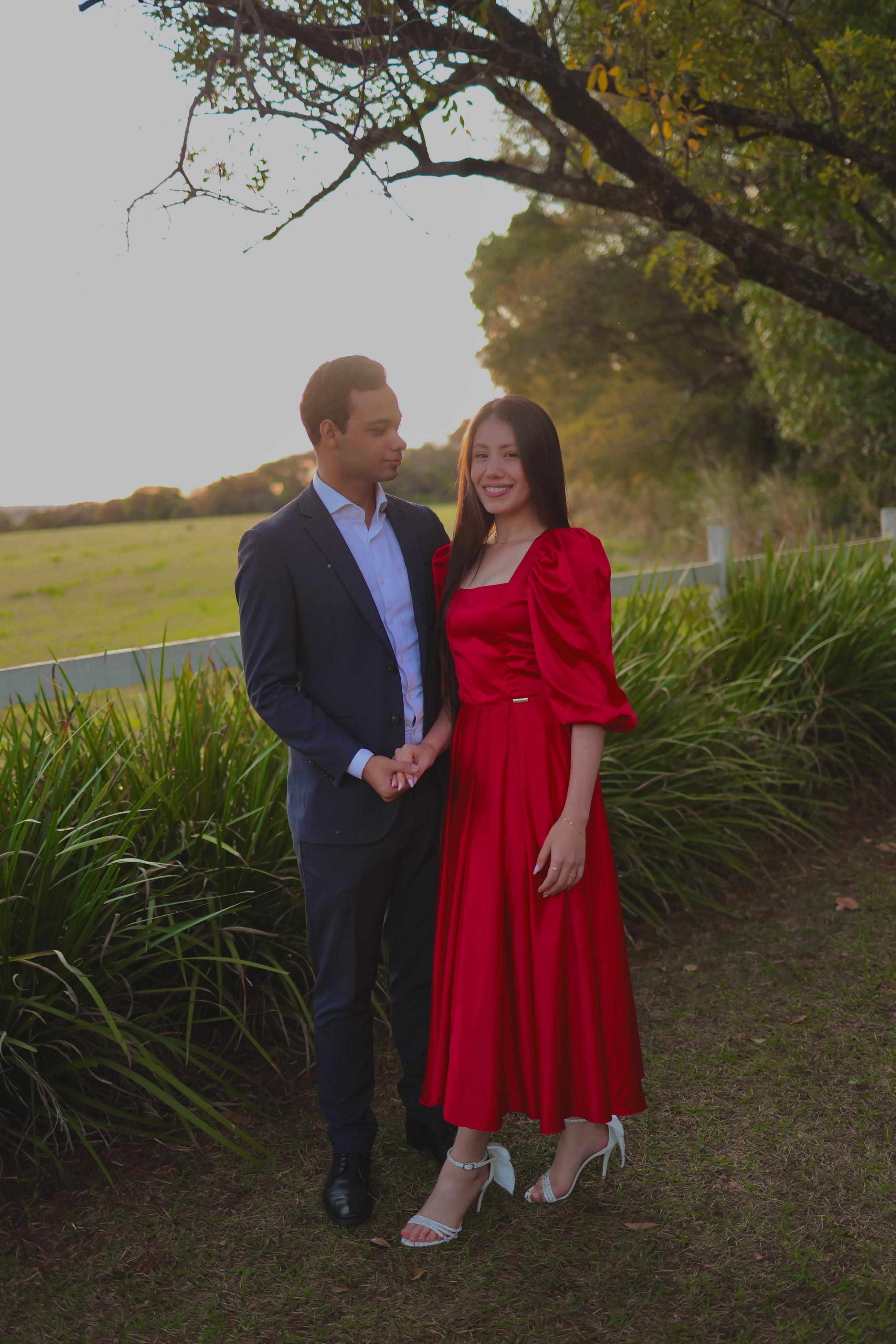 Angélica e Vinicius de mãos dadas no jardim, à luz do pôr do sol
